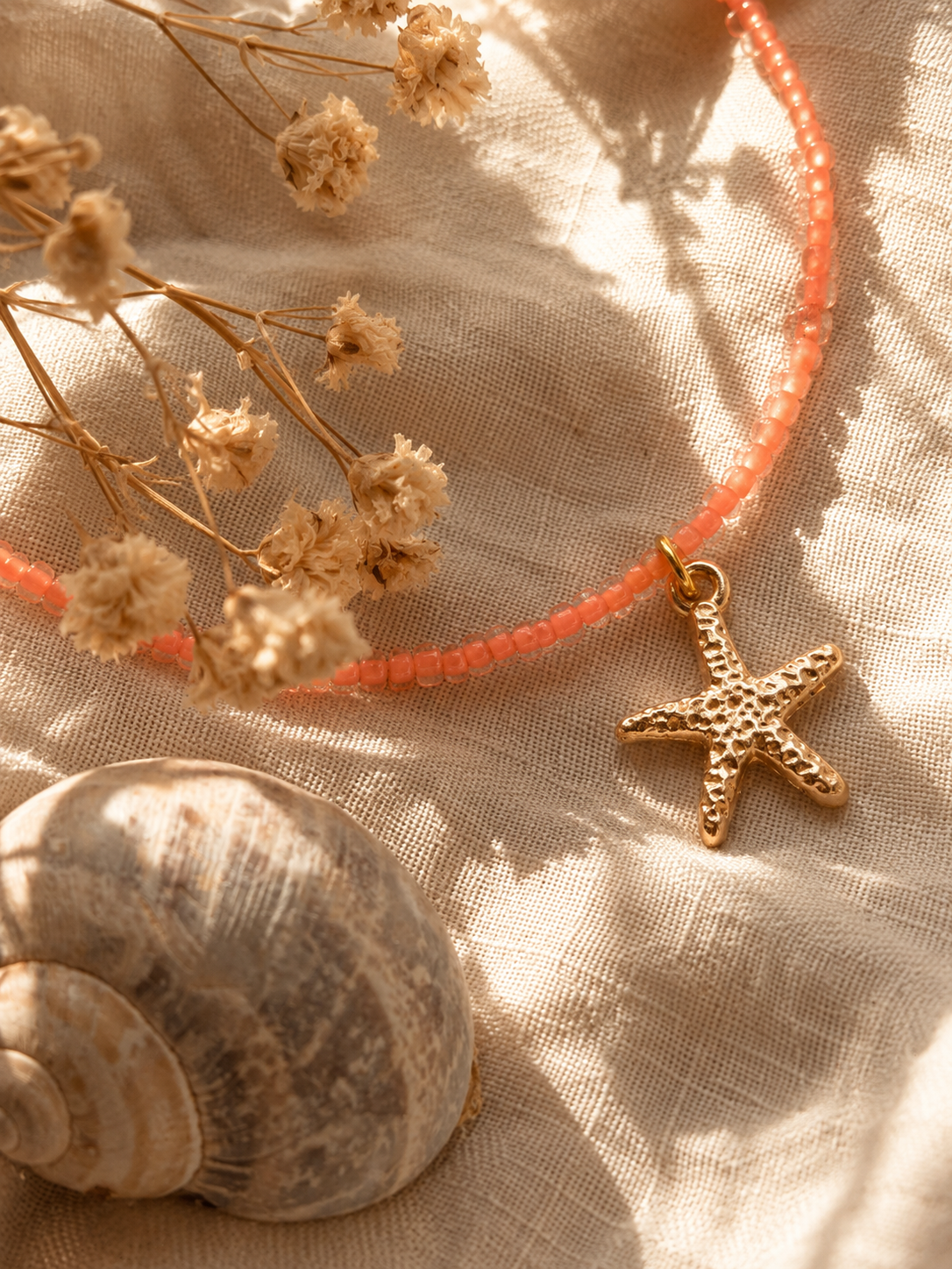 op een linnen doek ligt een gouden bedel van zeester met relief erin
