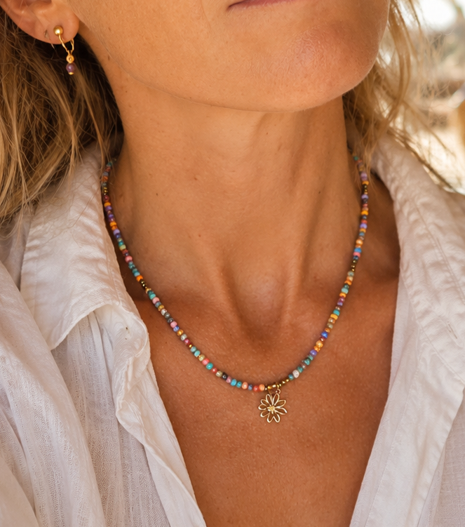 model draagt kleurrijke ketting bali stijl met bloem