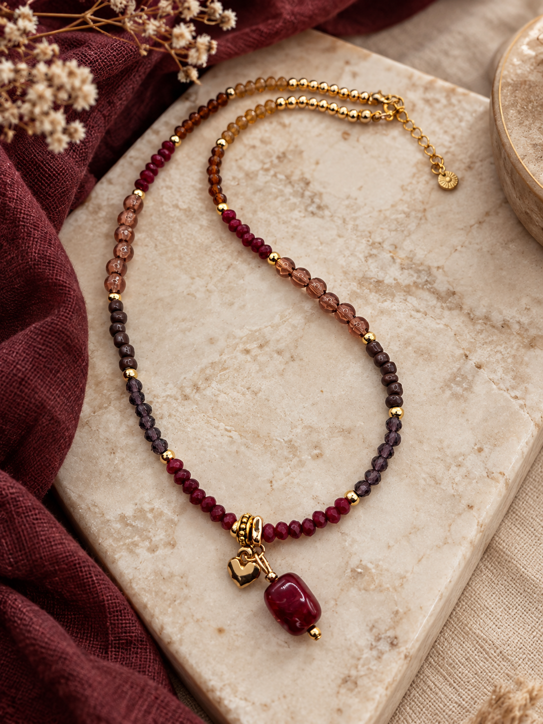 Burgundy Bloom bordeaux kralenketting met rode hanger en goudkleurige details