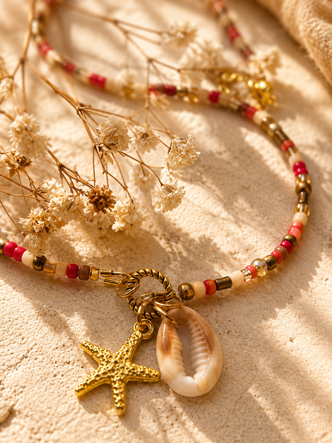 Detailfoto van een boho kralenketting met natuurlijke schelp en gouden zeester bedel van Blissh.