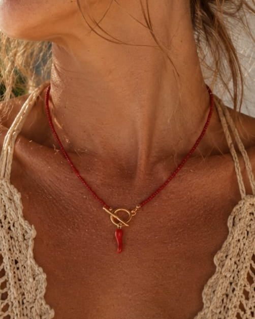 Rode handgemaakte ketting met corno-bedel gedragen als minimalistische statement ketting.