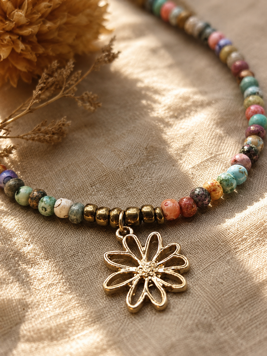 close up van bloembedeltje aan een kleurrijke bali kralenketting