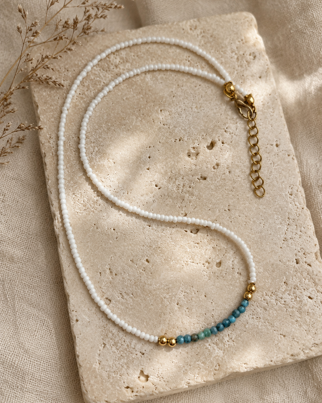 Handgemaakte witte kralenketting Pearl Coast met blauwgroen kleuraccent en gouden details