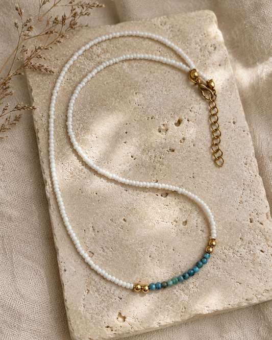 Handgemaakte witte kralenketting Pearl Coast met blauwgroen kleuraccent en gouden details