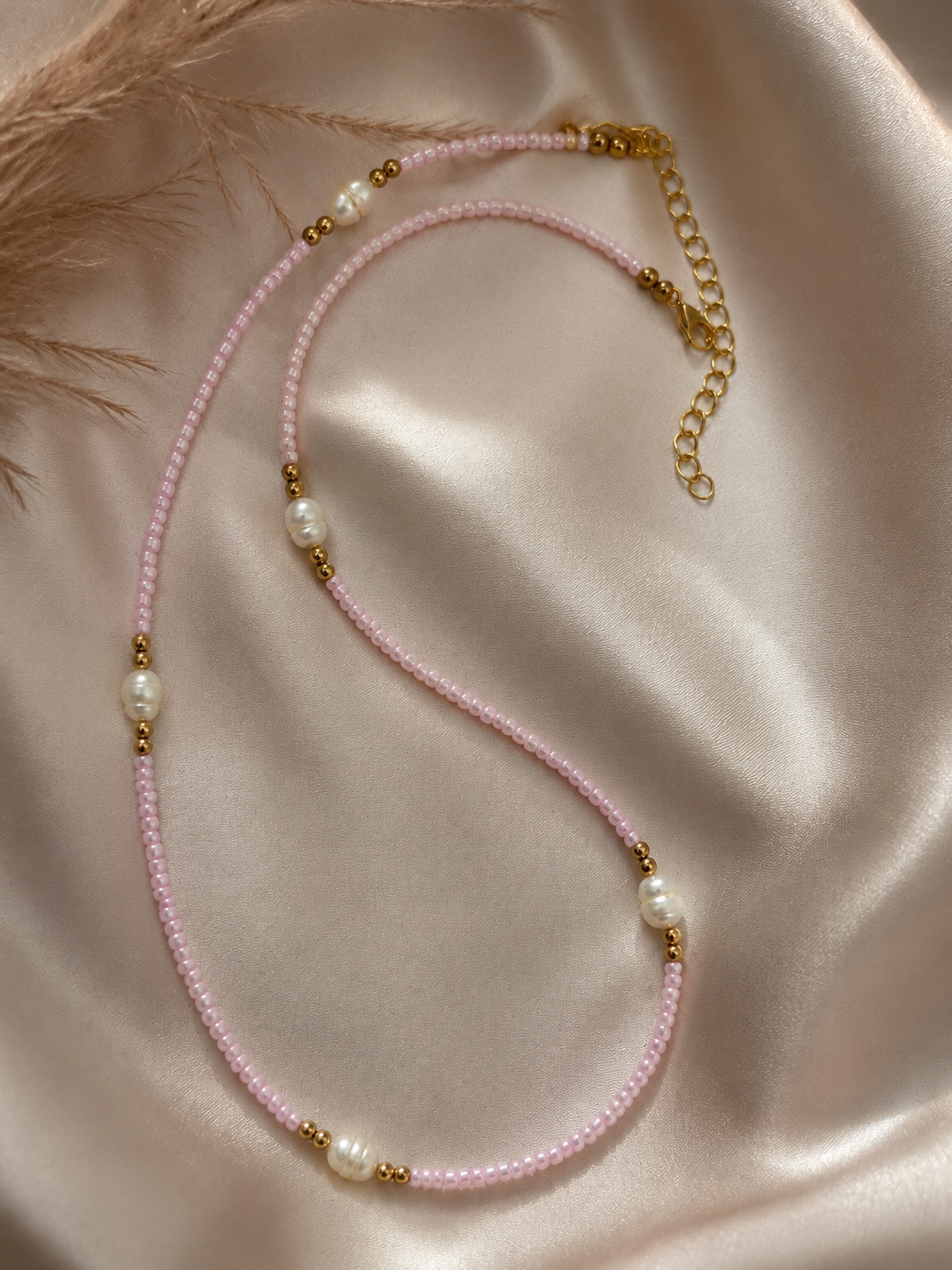 Roze kralenketting met echte zoetwaterparels en goudkleurige accenten