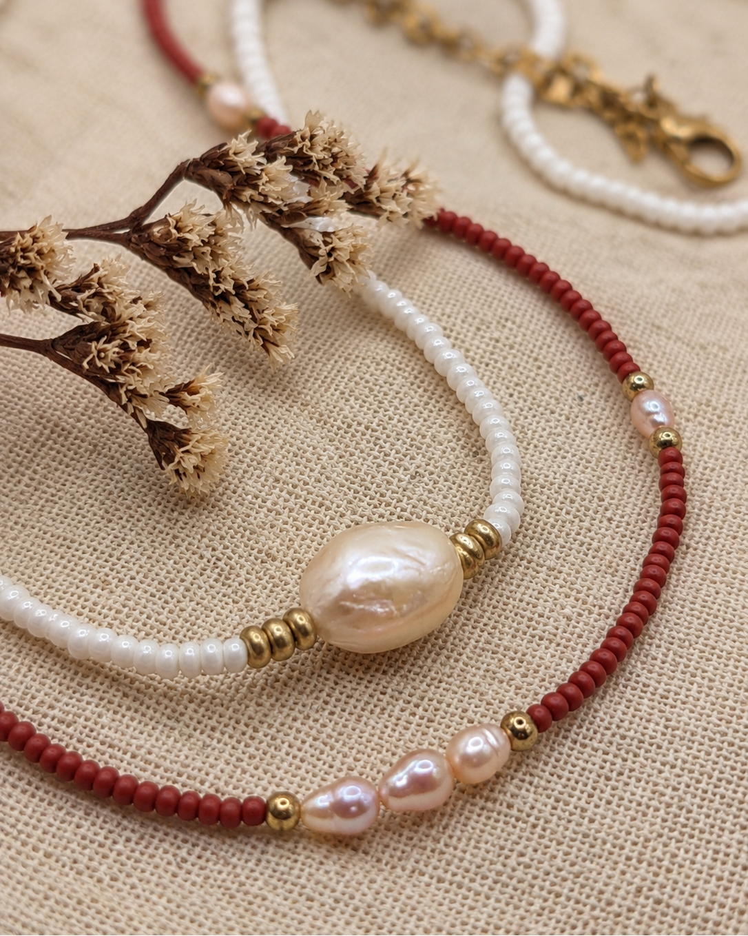Detail van rode kralenketting Terra Pearl met parels