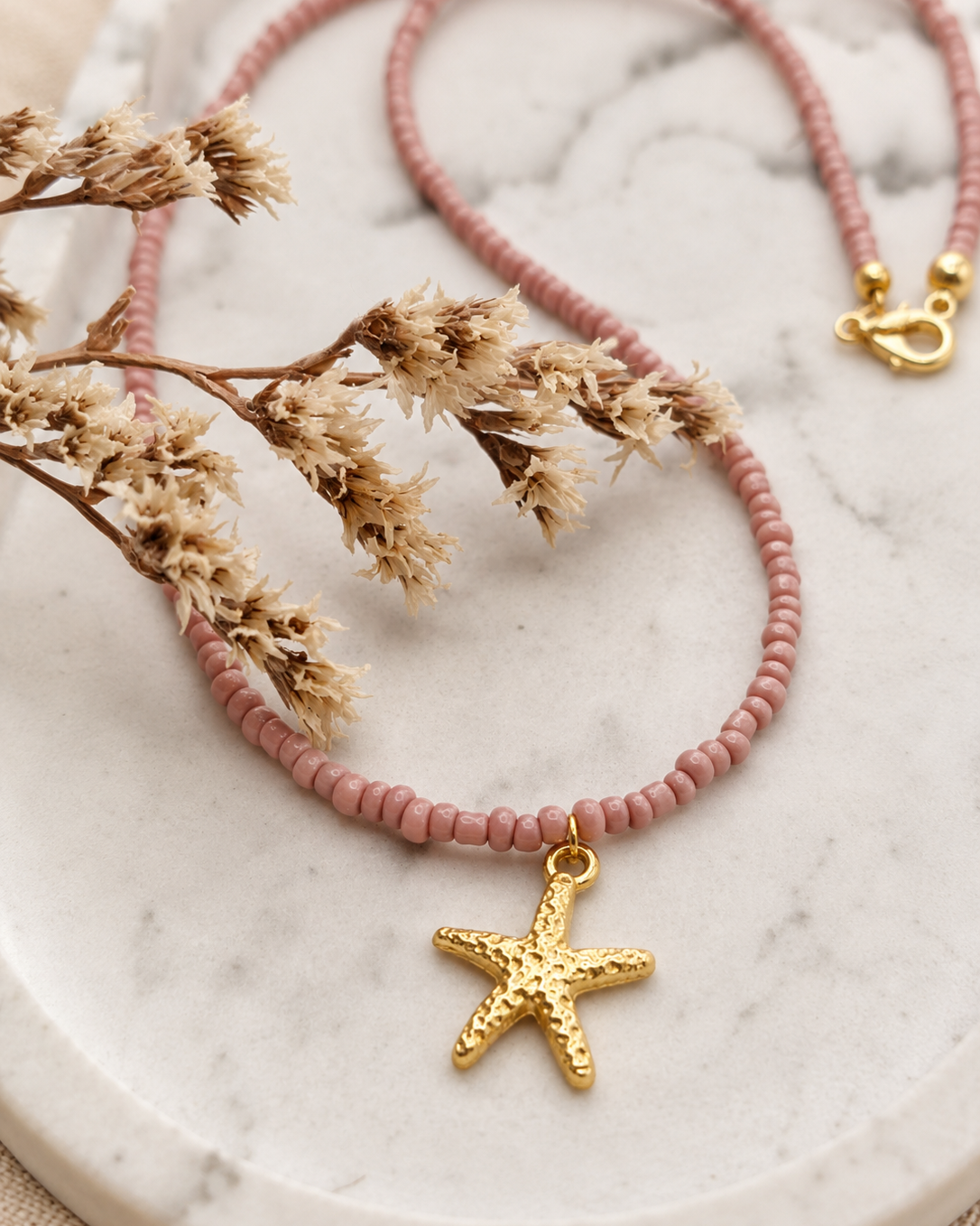 Detail van Vintage Rosé oudroze kralenketting met zeester