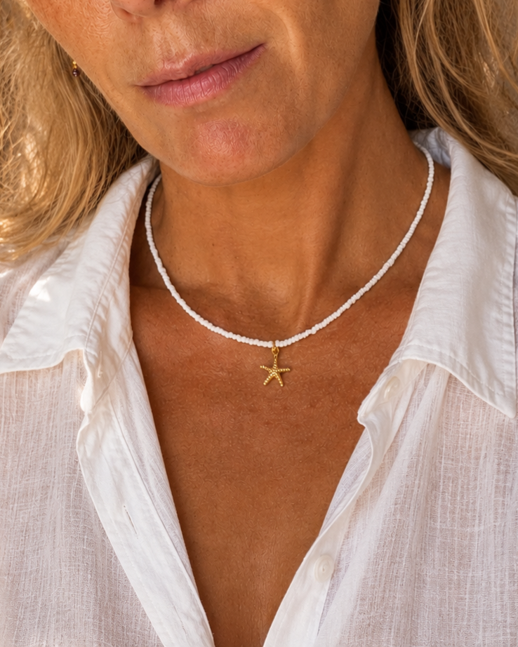 witte kralenketting met zeester op model met linnen blouse