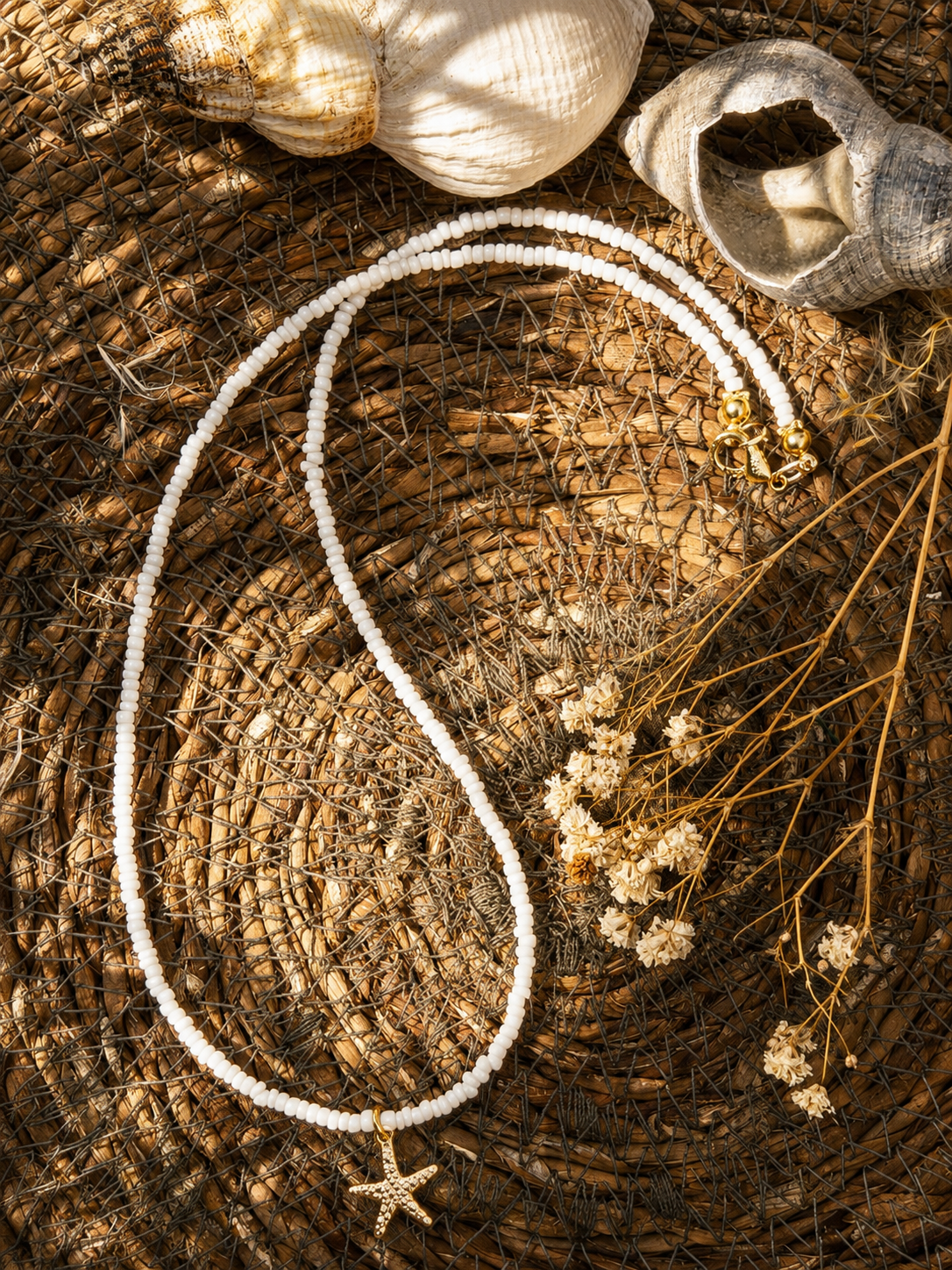handgemaakte witte kralenketting met goudenzeester
